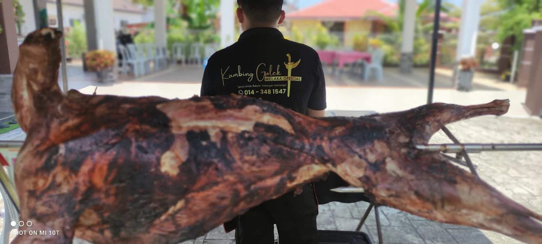 Krew mengangkat kambing golek yang sudah masak sempurna