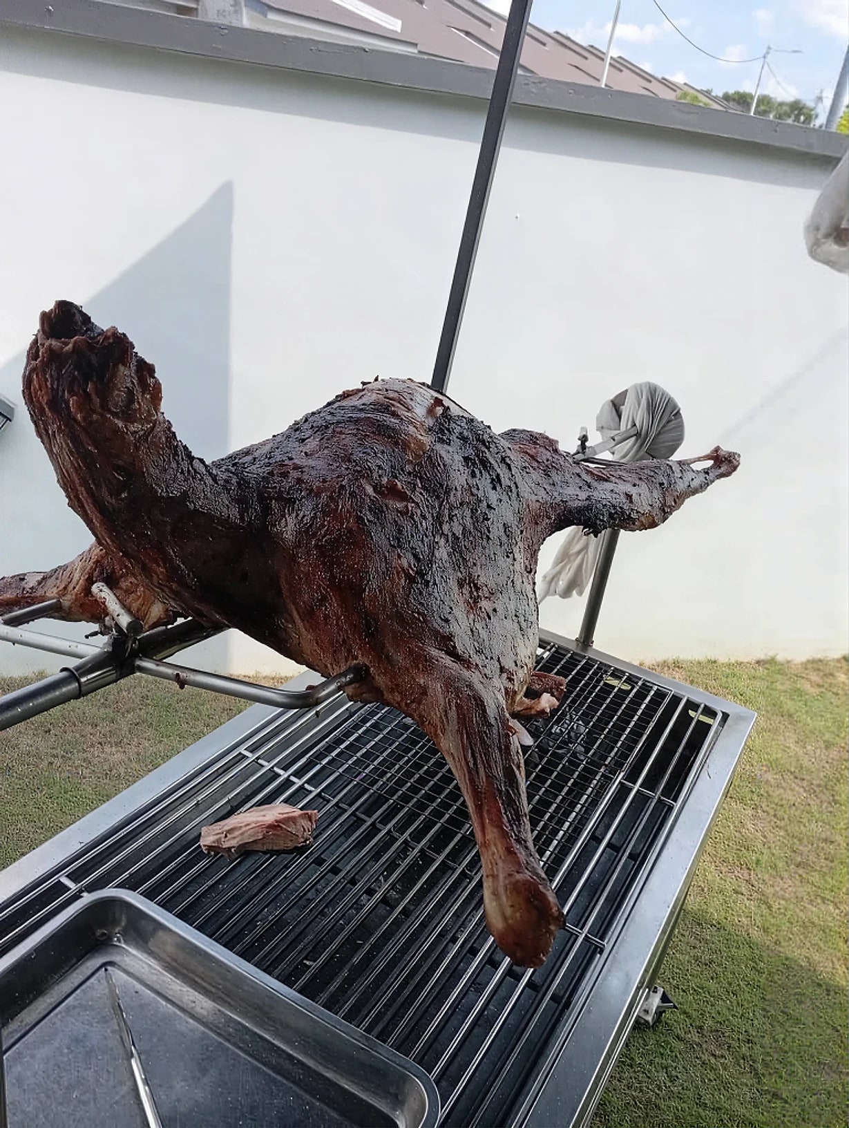 Kambing golek di atas pemanggang di halaman rumah