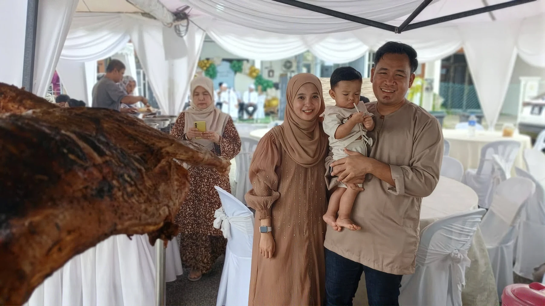 Keluarga bergambar bersama kambing golek majlis mereka